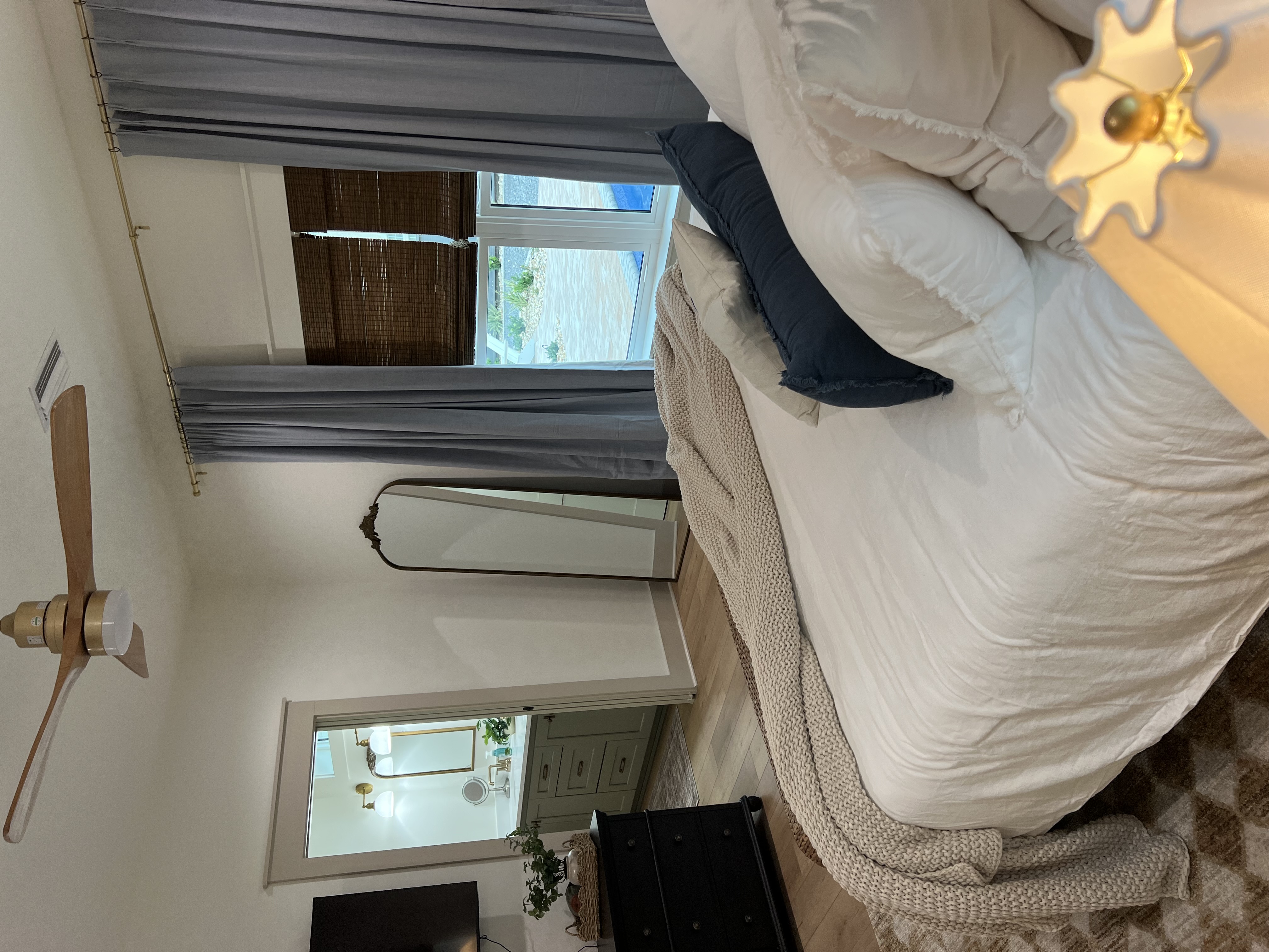 Master bedroom linens and gold sconce